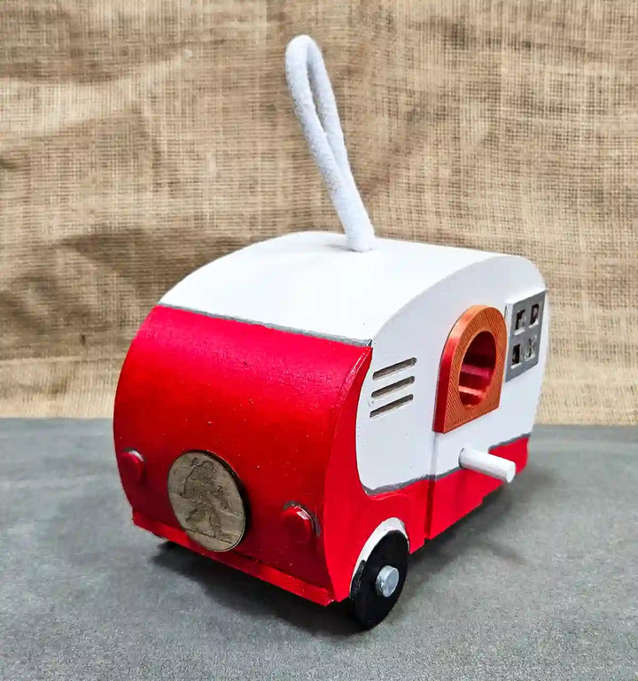 Angle view of the red 'Wrennabago' retro camper birdhouse, showing the side details and the overall camper shape.