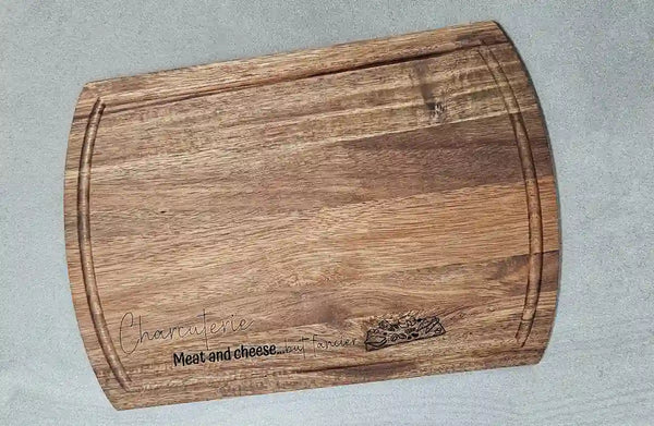 Top-down view of the rectangular Acacia wood charcuterie board, showing the smooth surface and the engraved design.