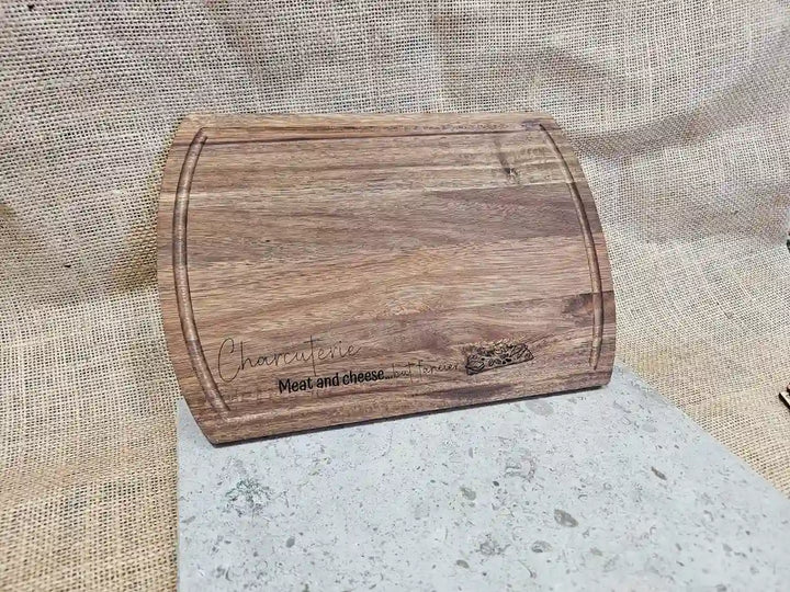 Angled side view of the rectangular Acacia wood charcuterie board, showing the wood's thickness and the rounded corners.