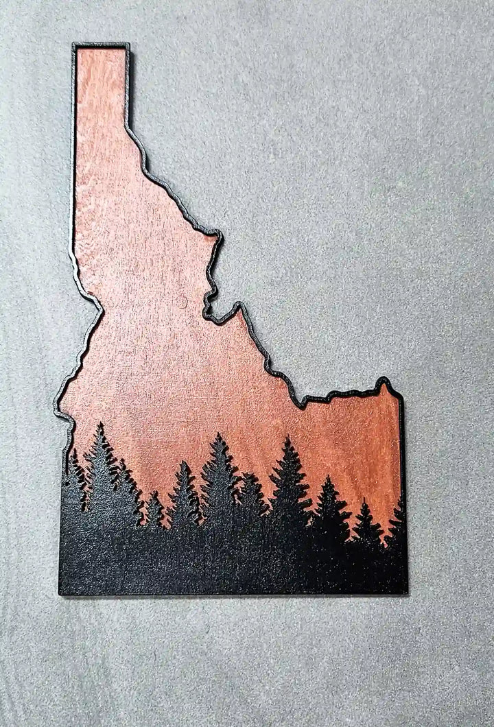 Close-up of the laser-cut Idaho state shape and the detailed tree silhouettes in the wooden art piece.