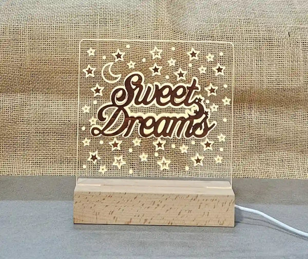 Two-layer nightlight with a wooden base and a clear acrylic panel featuring an engraved crescent moon, stars, and the words 'Sweet Dreams'.