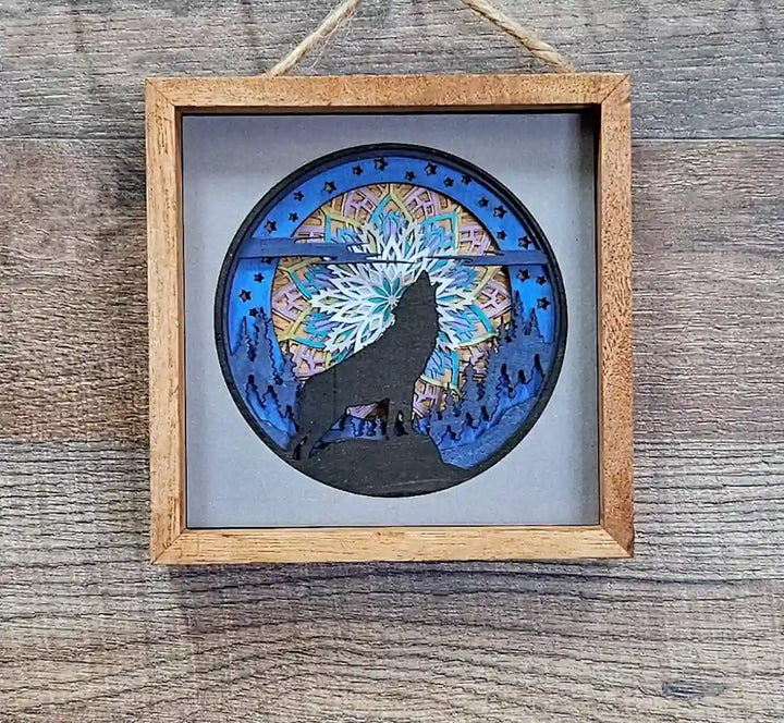 Square wooden shadow box with layered mandala and wolf design, displayed against a dark wood background.